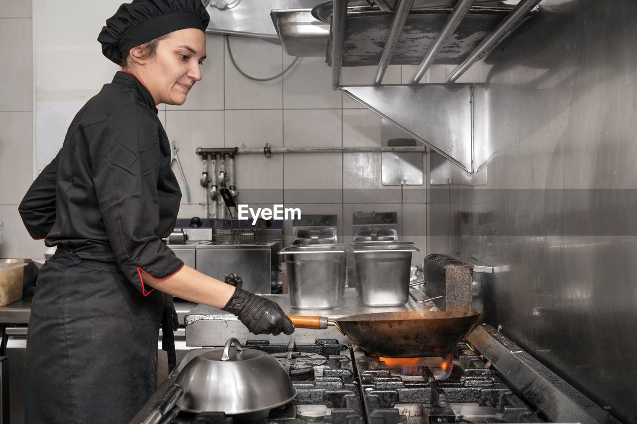 side view of man preparing food in kitchen