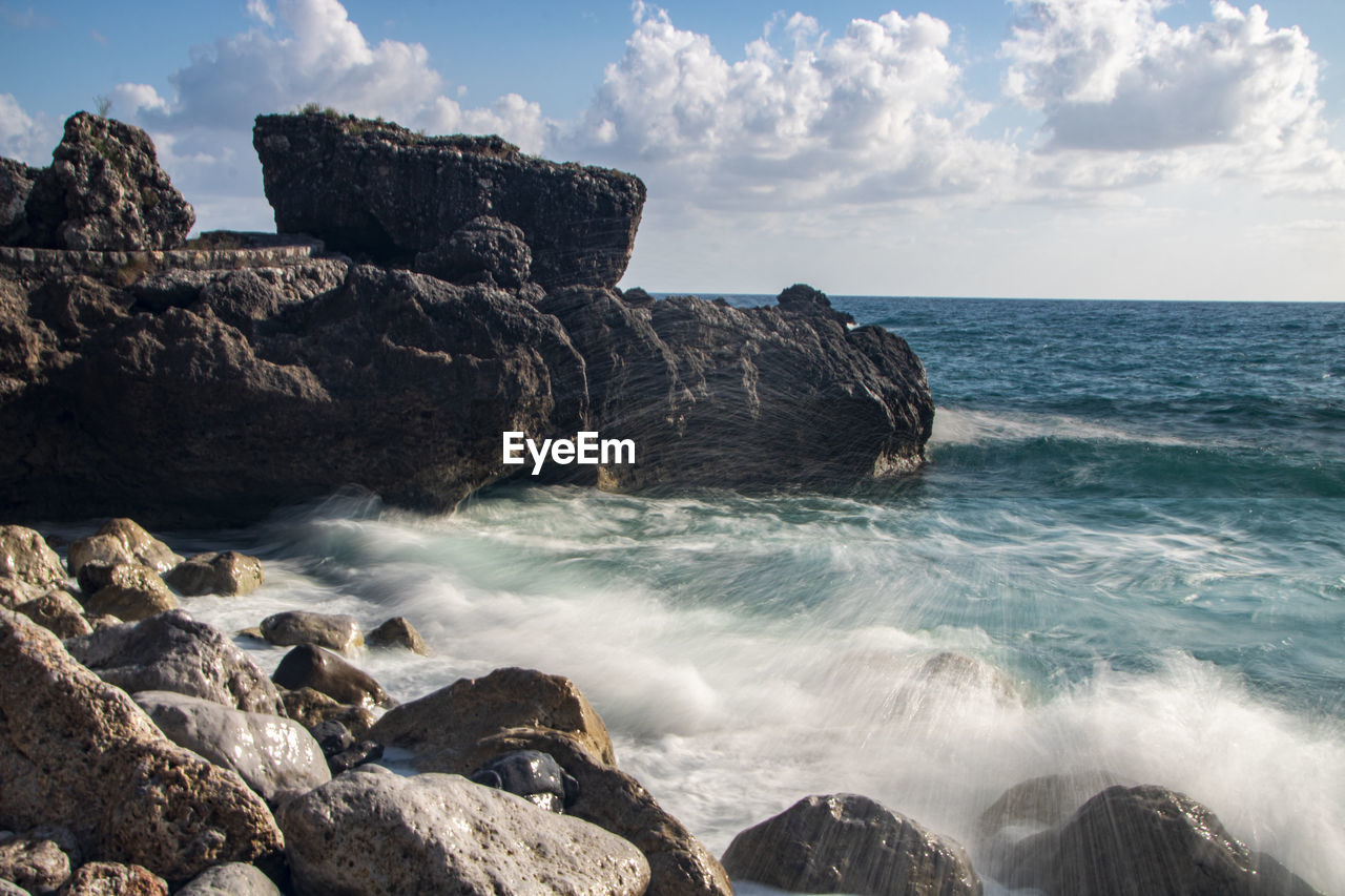 SCENIC VIEW OF ROCKS ON SHORE AGAINST SKY