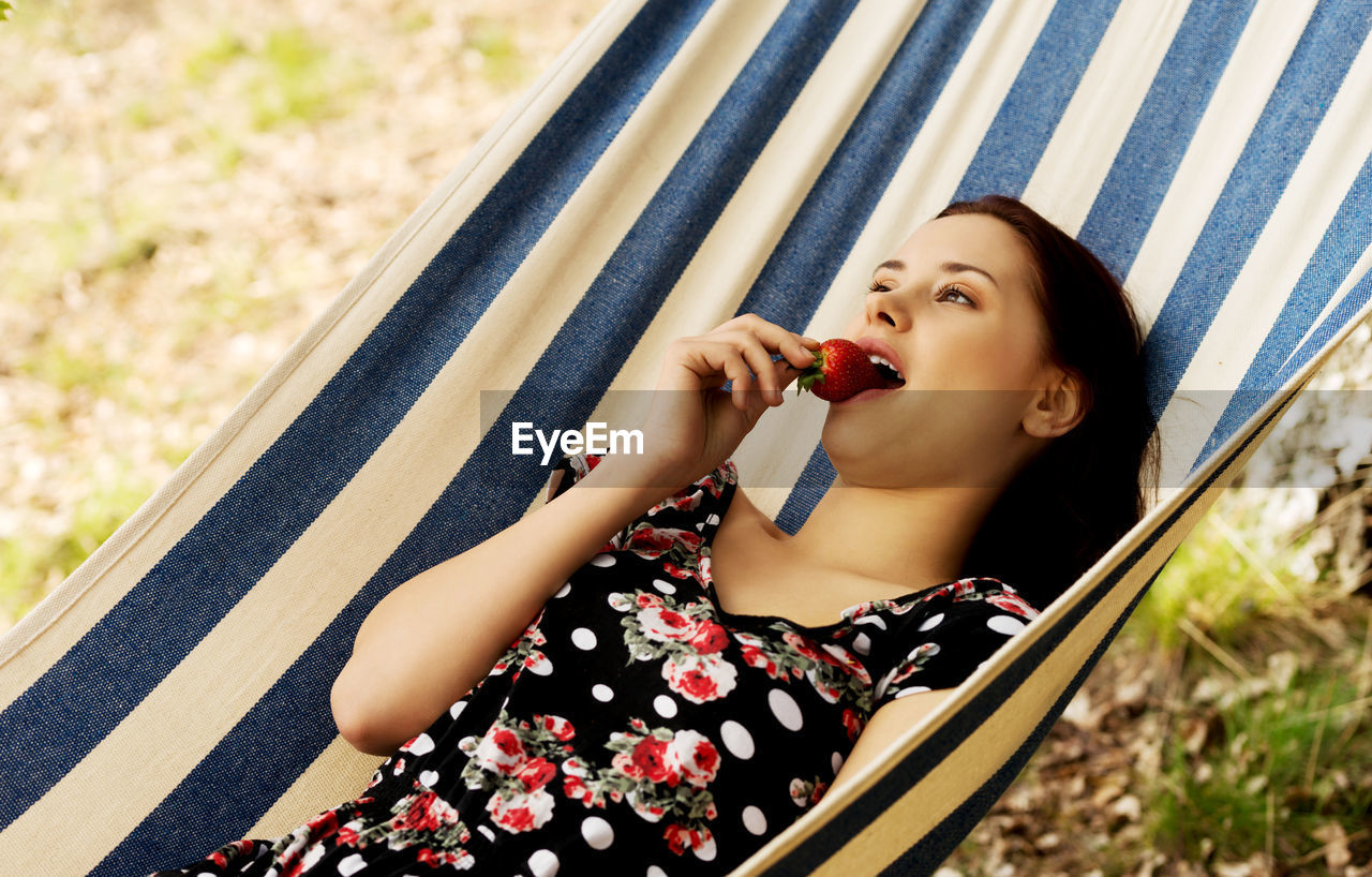 PORTRAIT OF YOUNG WOMAN EATING FOOD