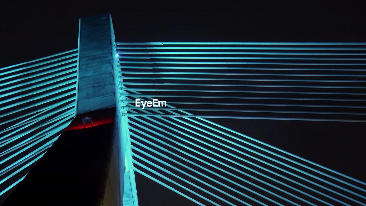 Low angle view of illuminated bridge against clear sky at night