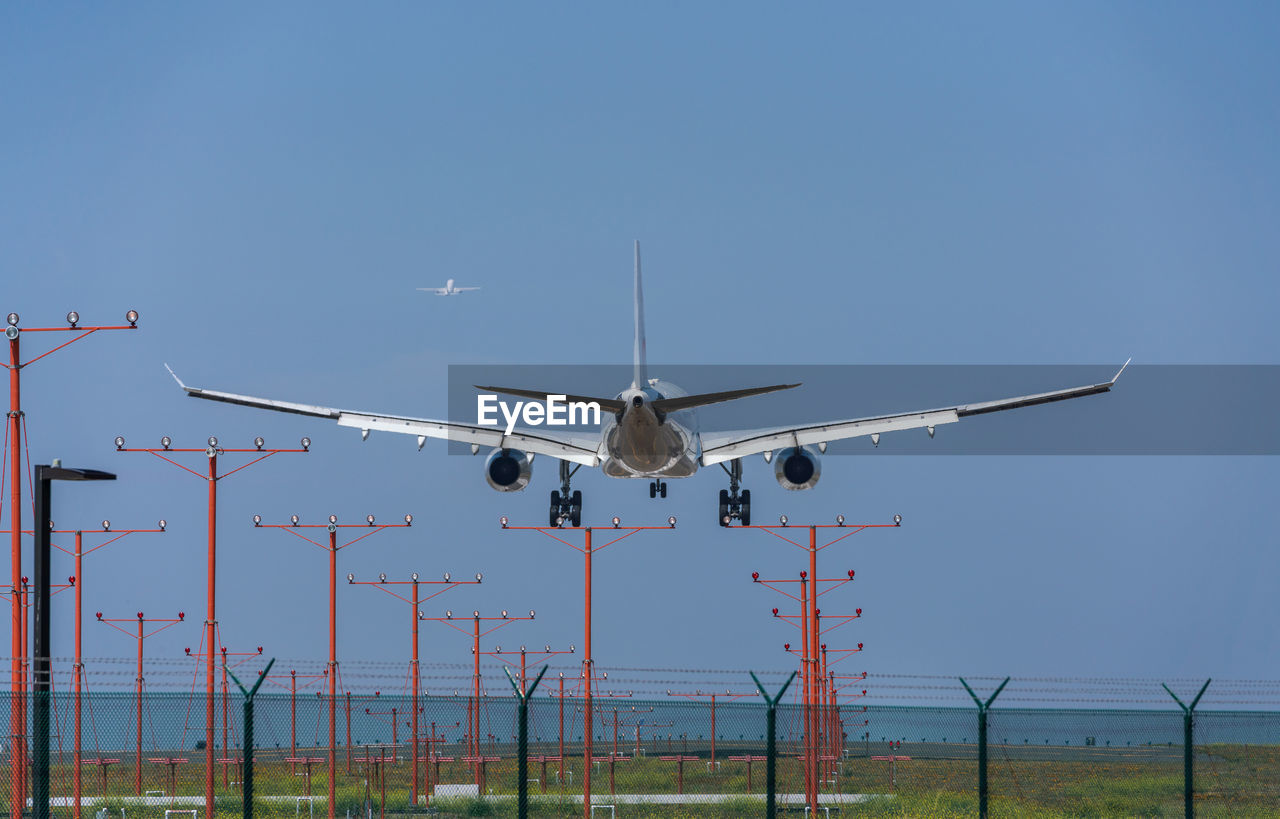 LOW ANGLE VIEW OF AIRPLANE FLYING AGAINST CLEAR SKY