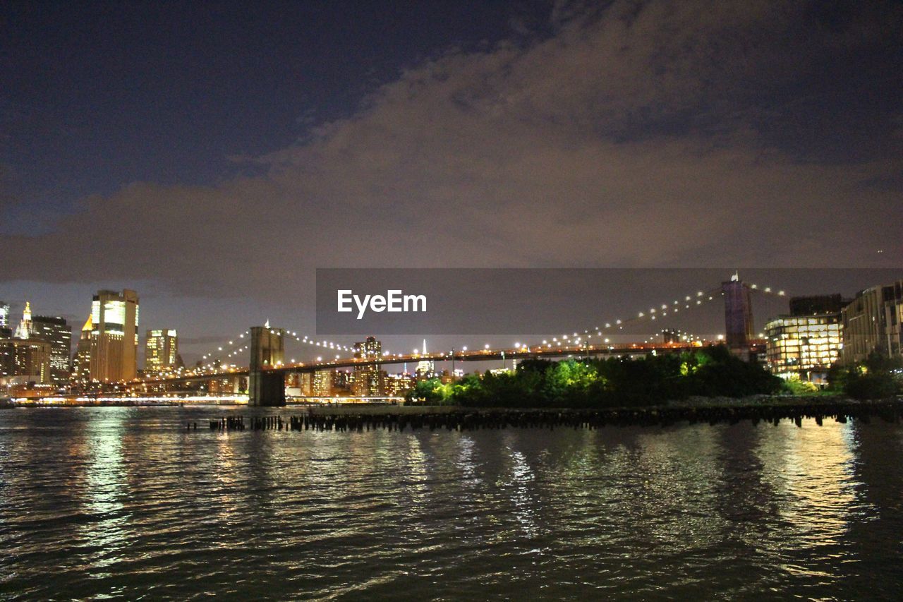 SUSPENSION BRIDGE OVER RIVER AT NIGHT