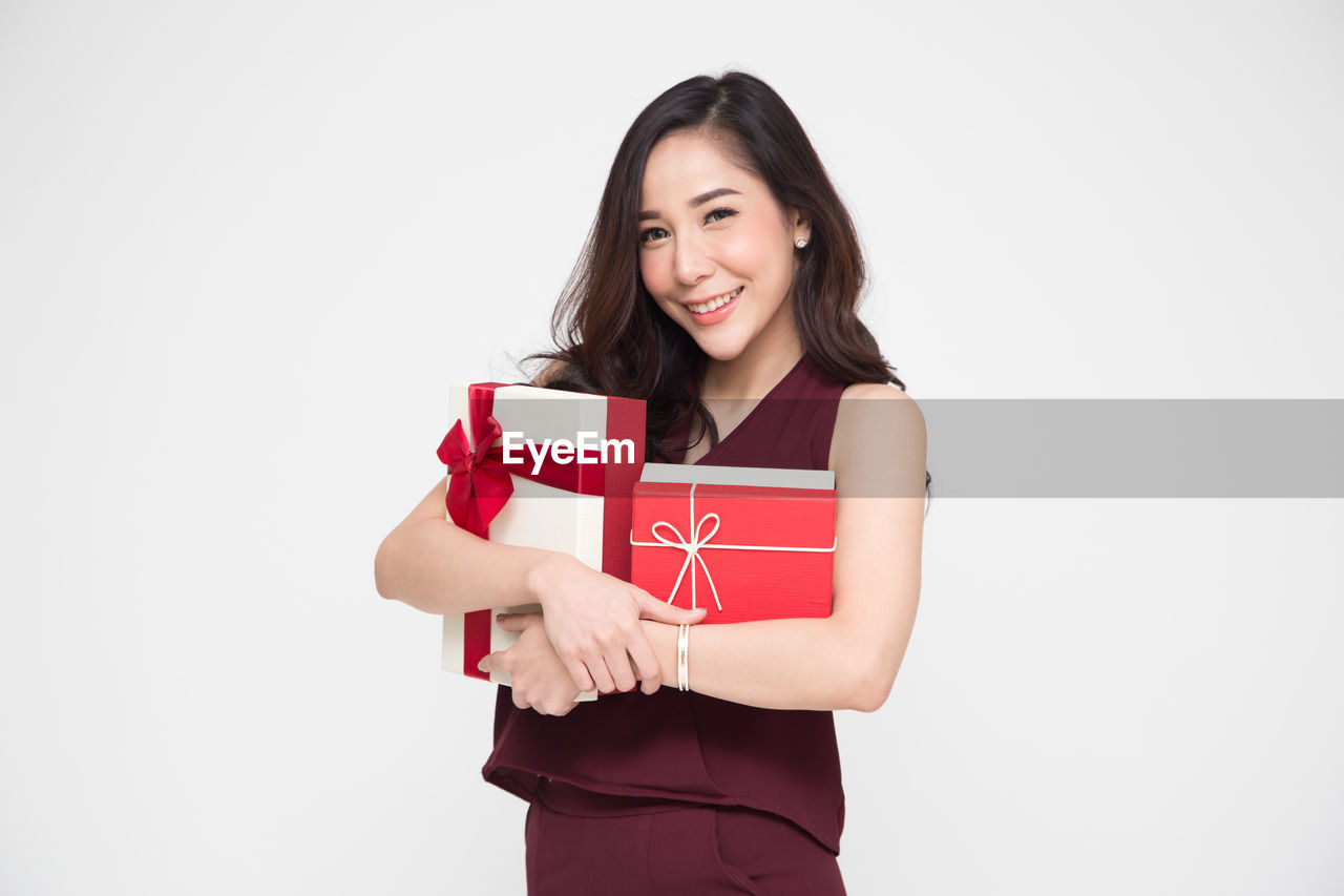 PORTRAIT OF A SMILING YOUNG WOMAN AGAINST THE BACKGROUND