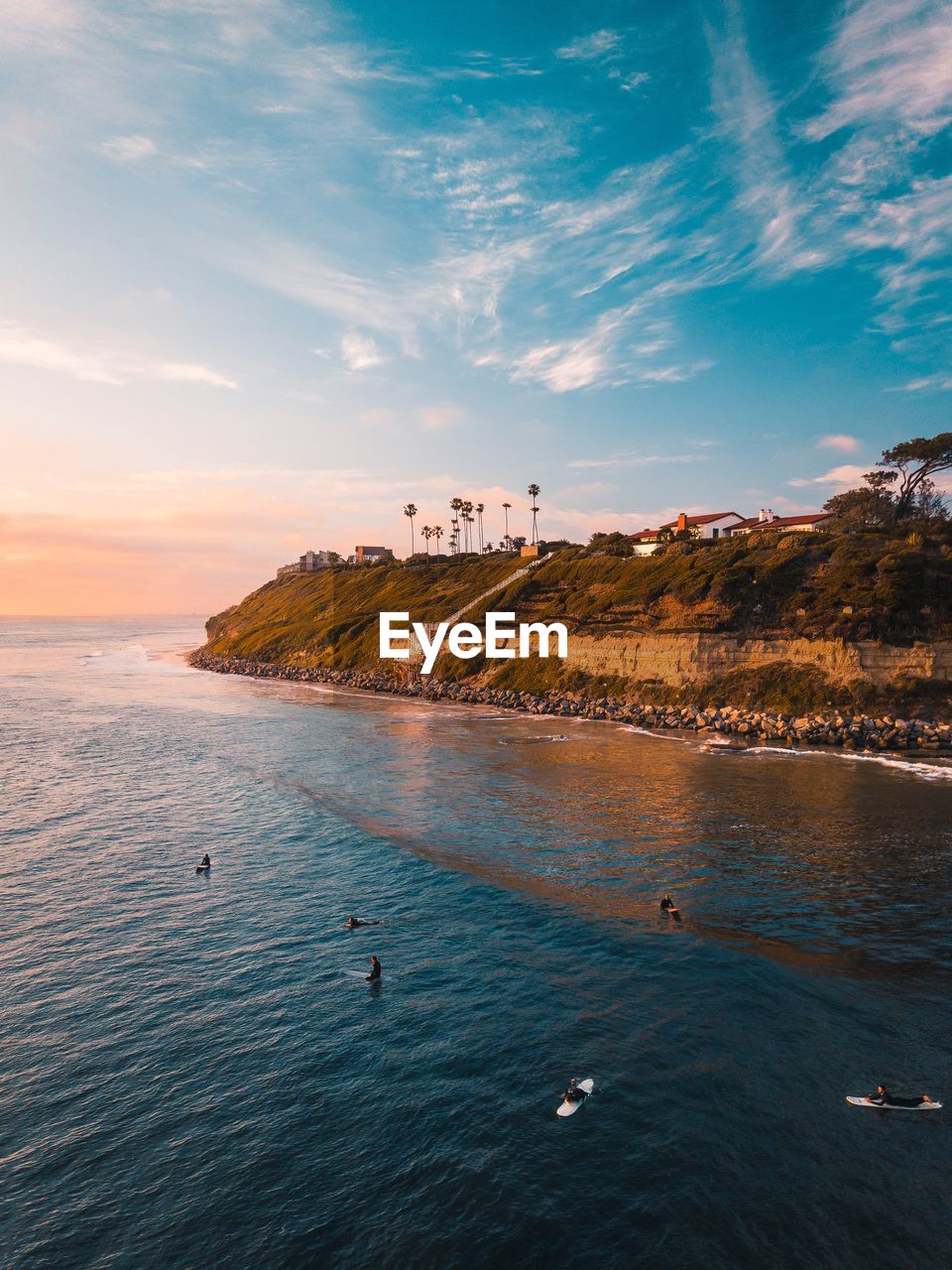 Scenic view of surfers off the coast from above