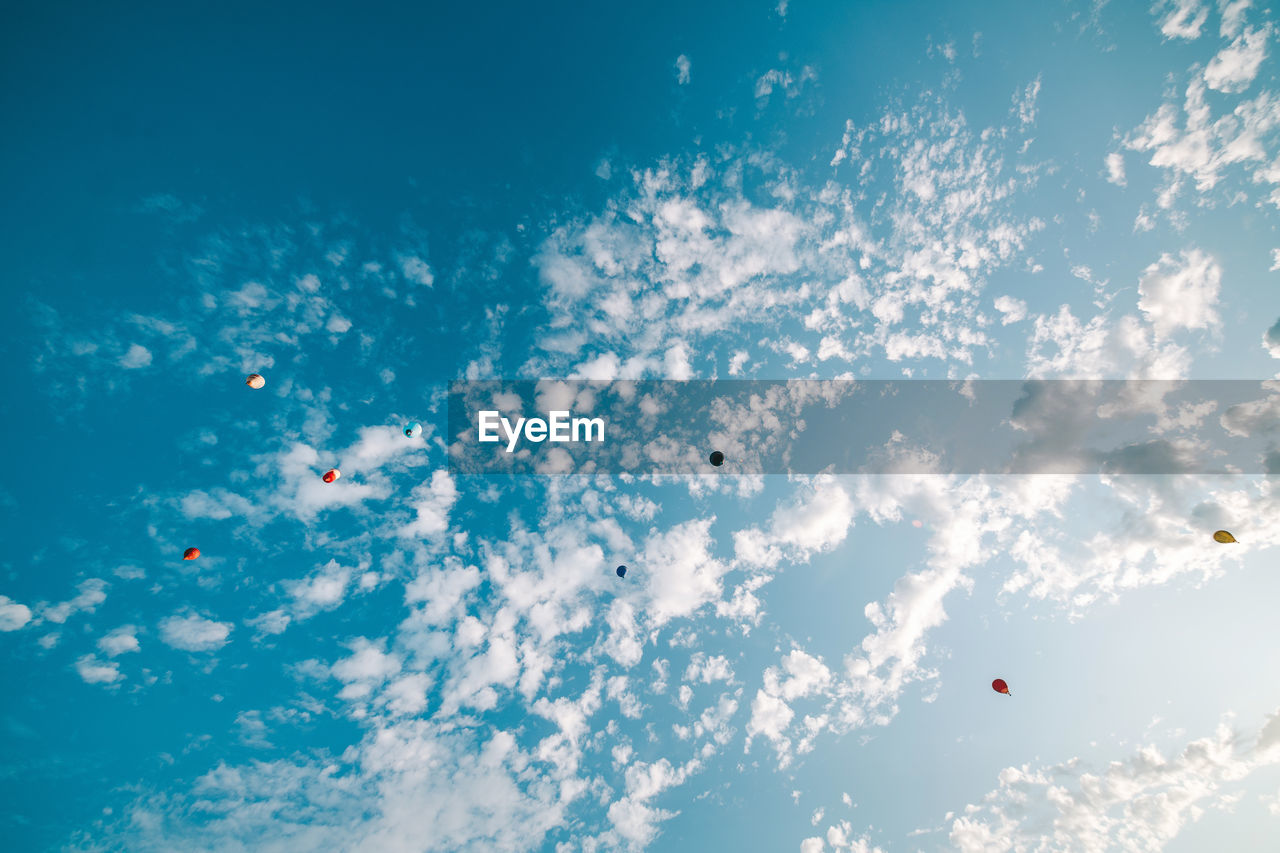 LOW ANGLE VIEW OF BALLOONS FLYING AGAINST SKY