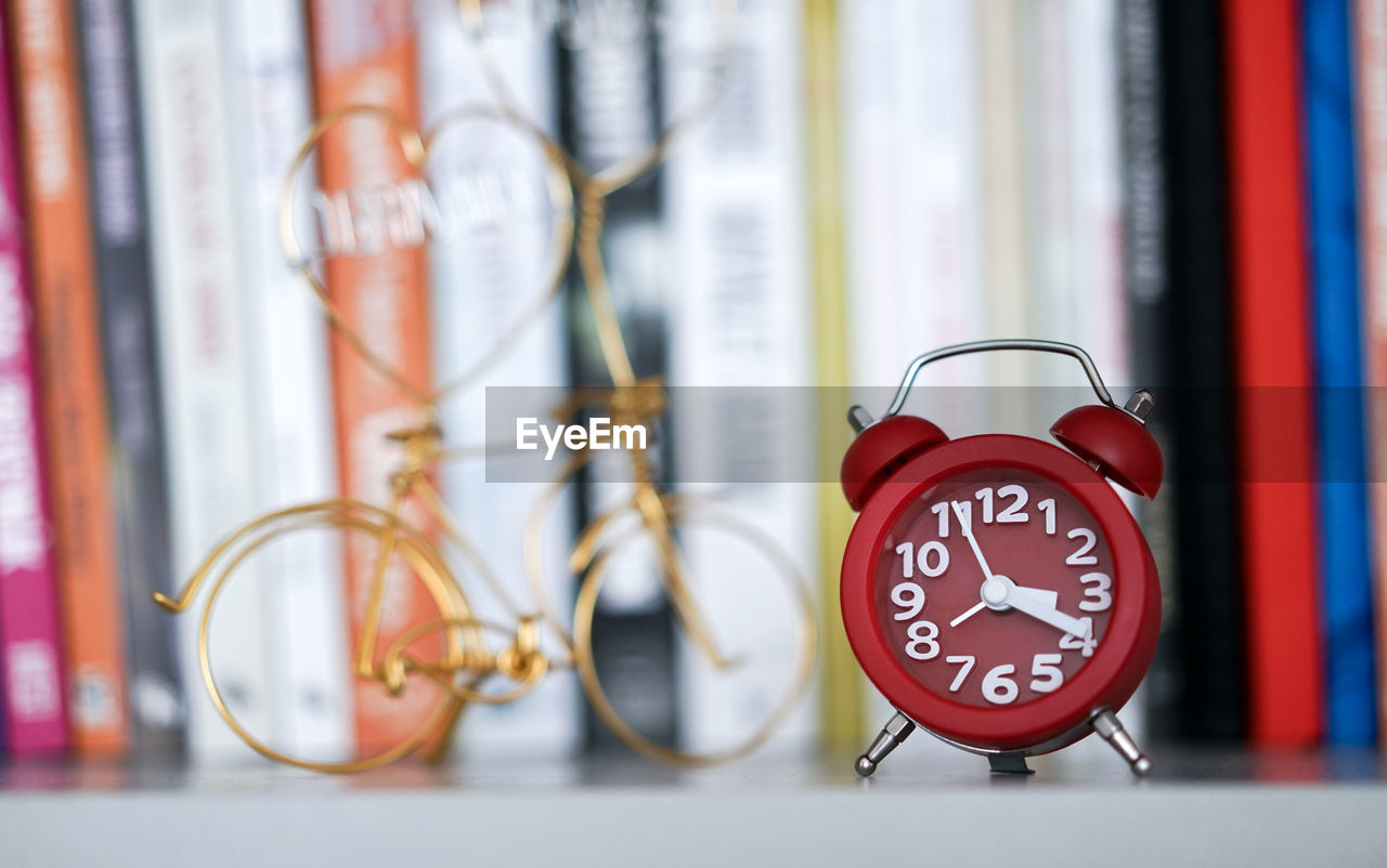 Close-up of alarm clock against books