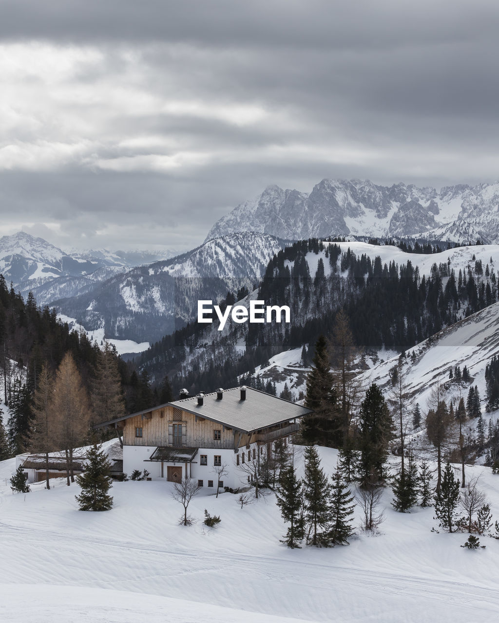 Hut in the mountains. view of scenic winter landscape and snowy mountains. bad weather is coming.