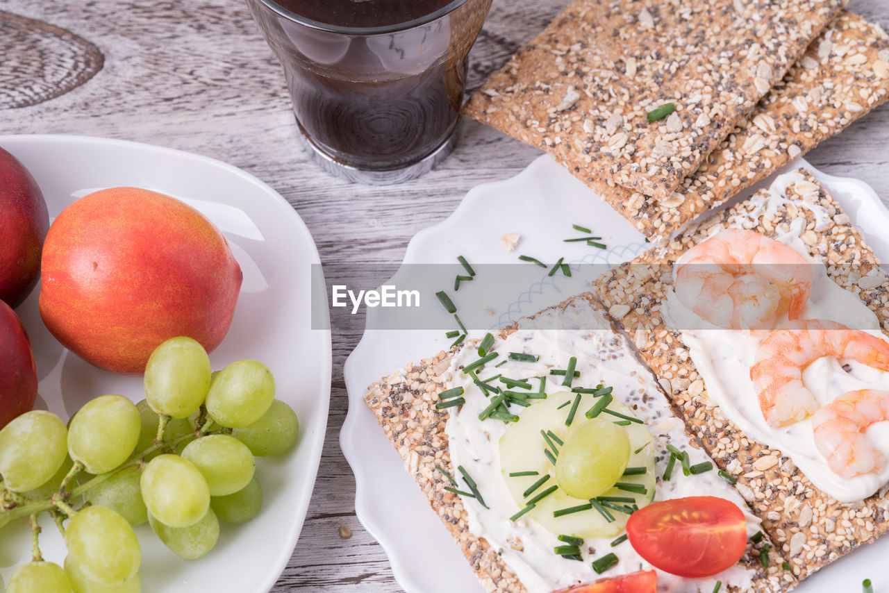 High angle view of fruits by food in plate on table