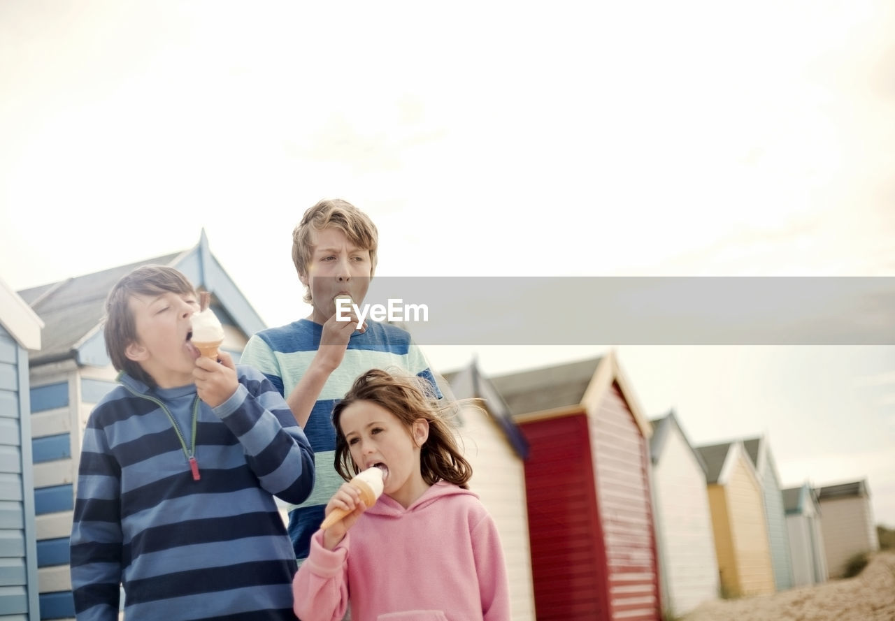 Girl and boys having ice cream at beach