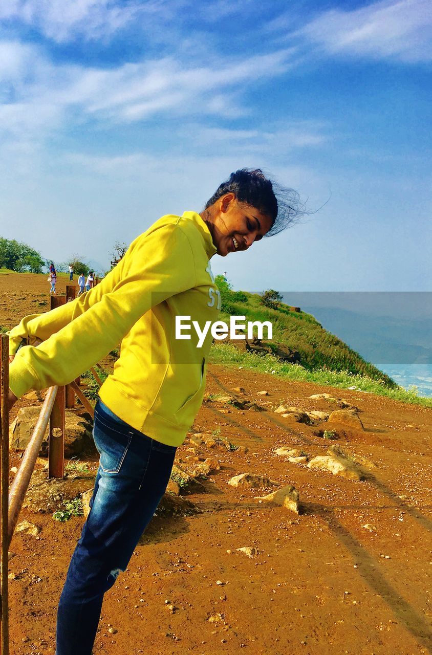 Side view of happy woman standing on land