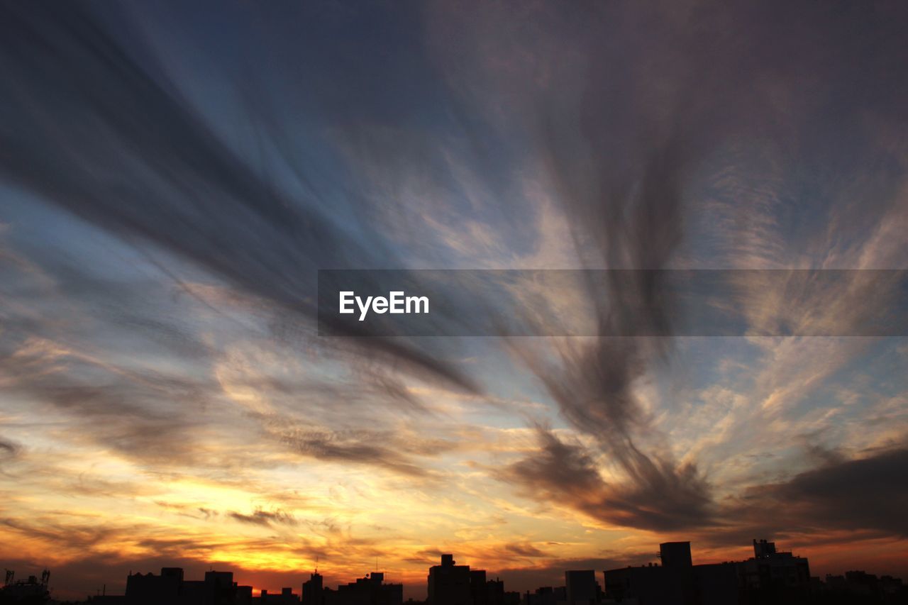 Silhouette city against sky during sunset