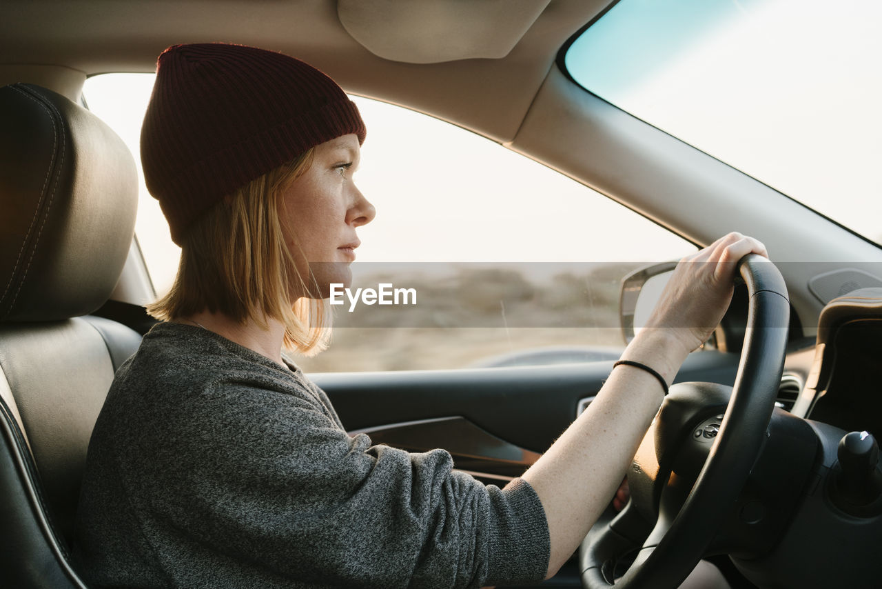 Inside view of woman driving in big sur at sunset