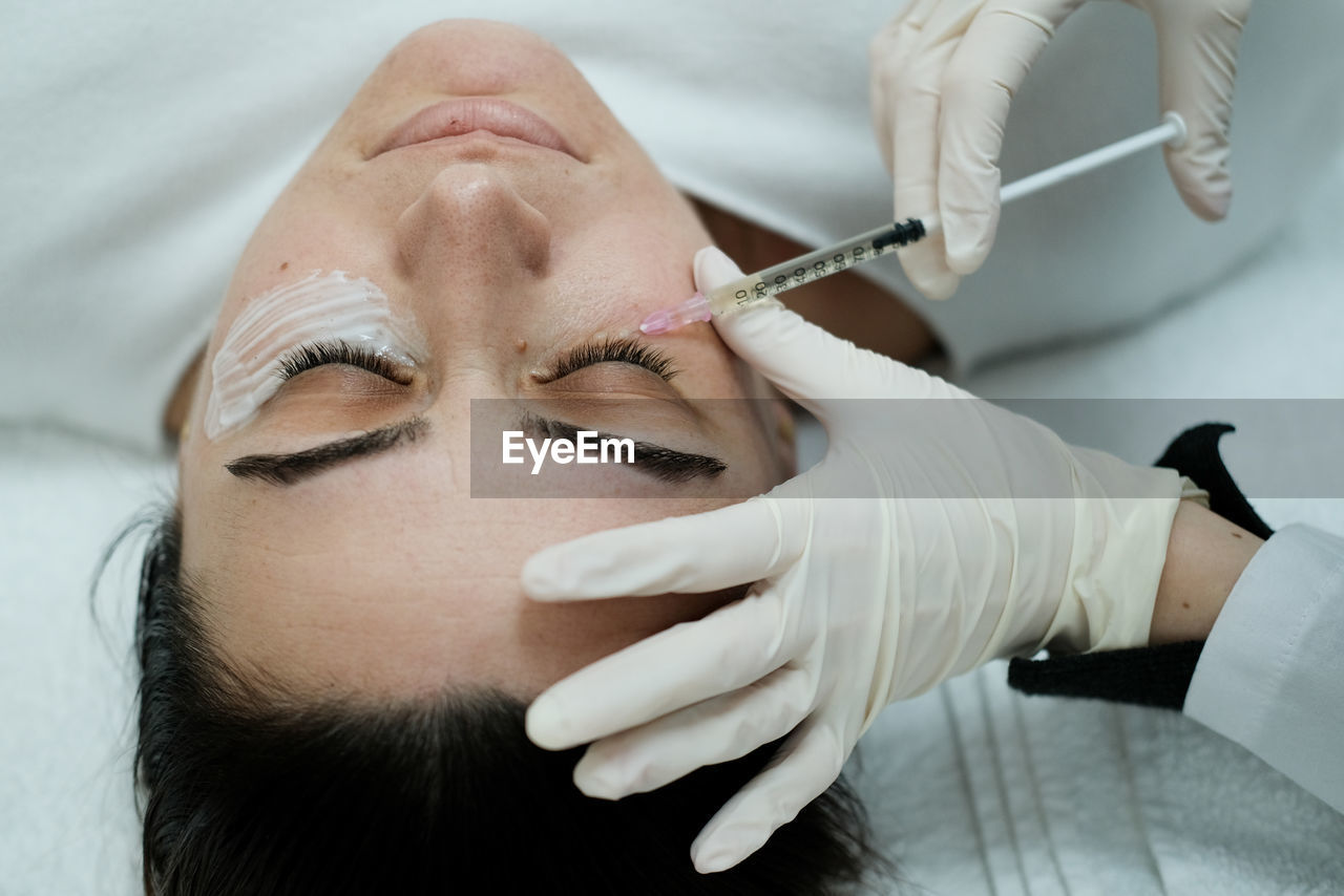 Top view of female patient having eye mesotheraphy applied