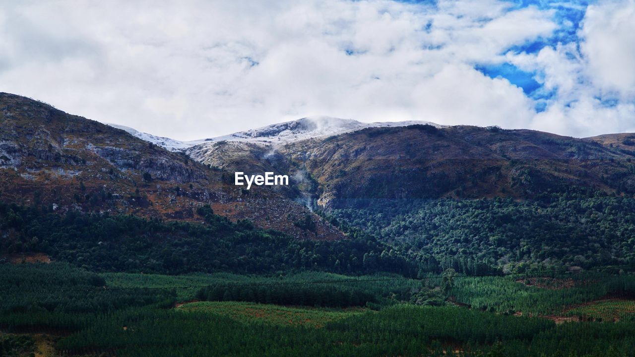 Scenic view of mountains against cloudy sky