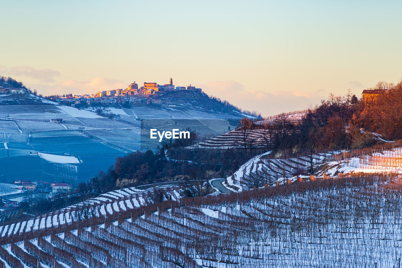 HIGH ANGLE VIEW OF SNOWCAPPED MOUNTAINS AGAINST SKY DURING SUNSET