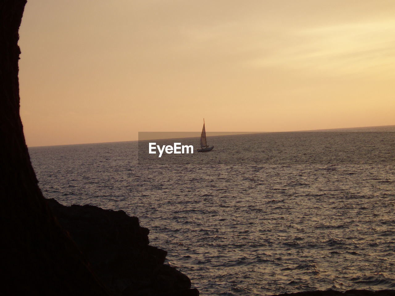 SAILBOAT SAILING ON SEA AGAINST SKY AT SUNSET