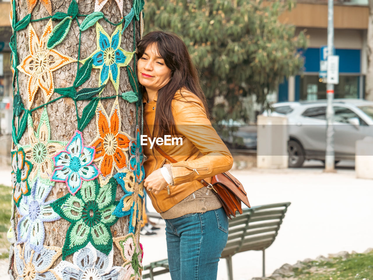 Portrait of young woman hugging a decorated tree