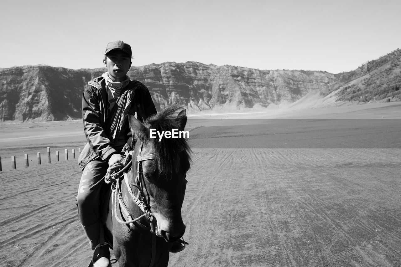 Portrait of man riding horse against sky