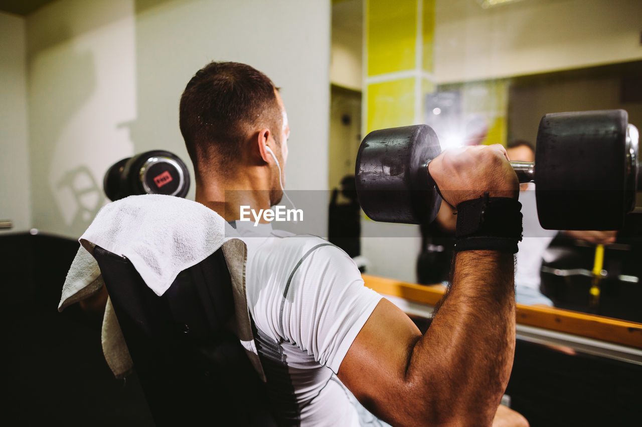 Man lifting dumbbells in gym