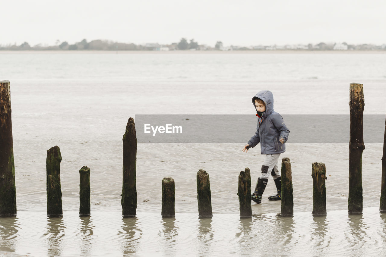 Boy walking on cold winter beach