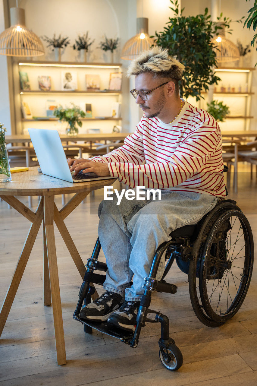 portrait of young woman sitting on wheelchair at home