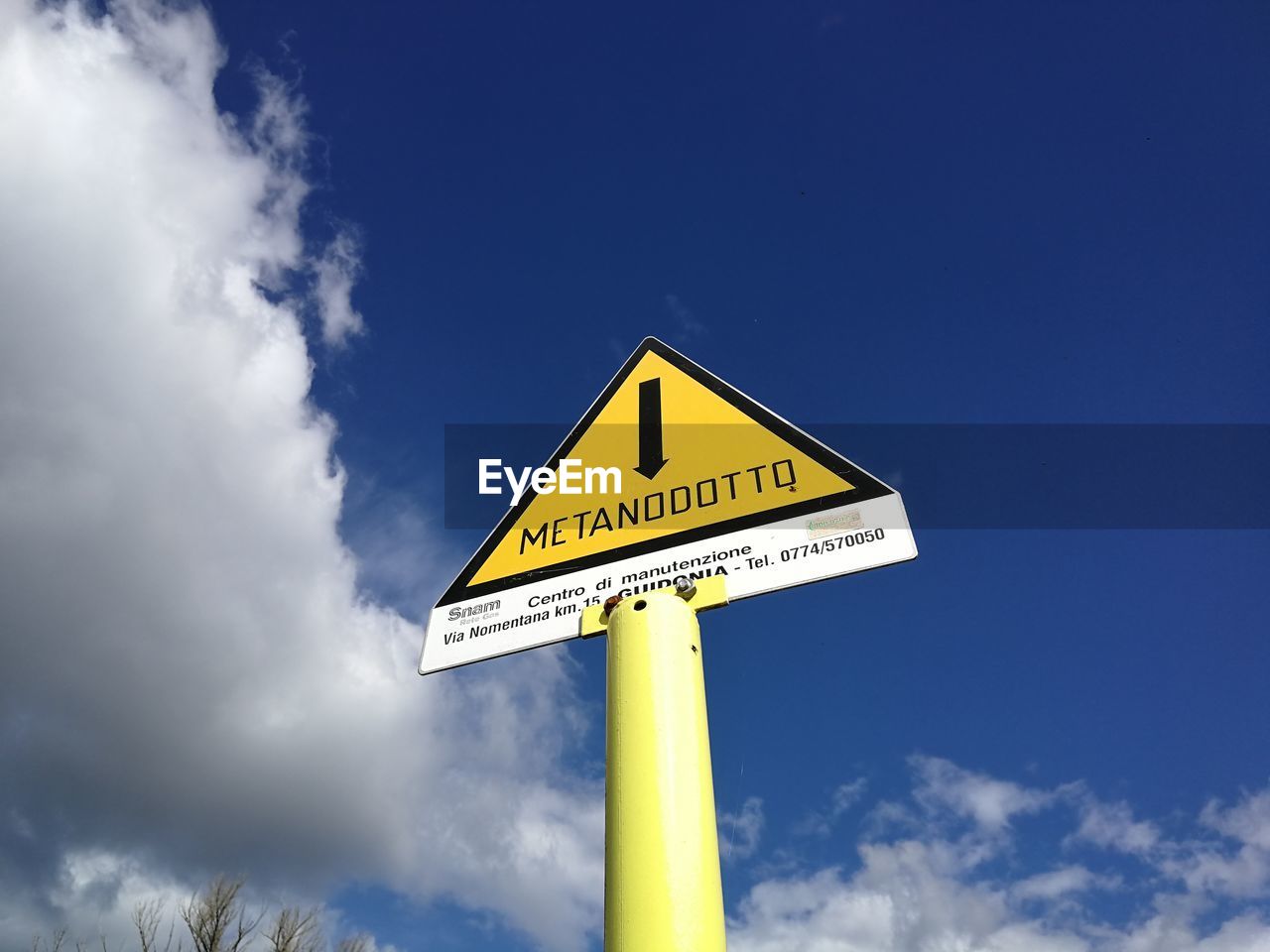 sign, communication, sky, cloud, yellow, road sign, warning sign, blue, traffic sign, nature, text, road, symbol, guidance, street sign, no people, western script, day, signage, low angle view, outdoors, directional sign, arrow symbol