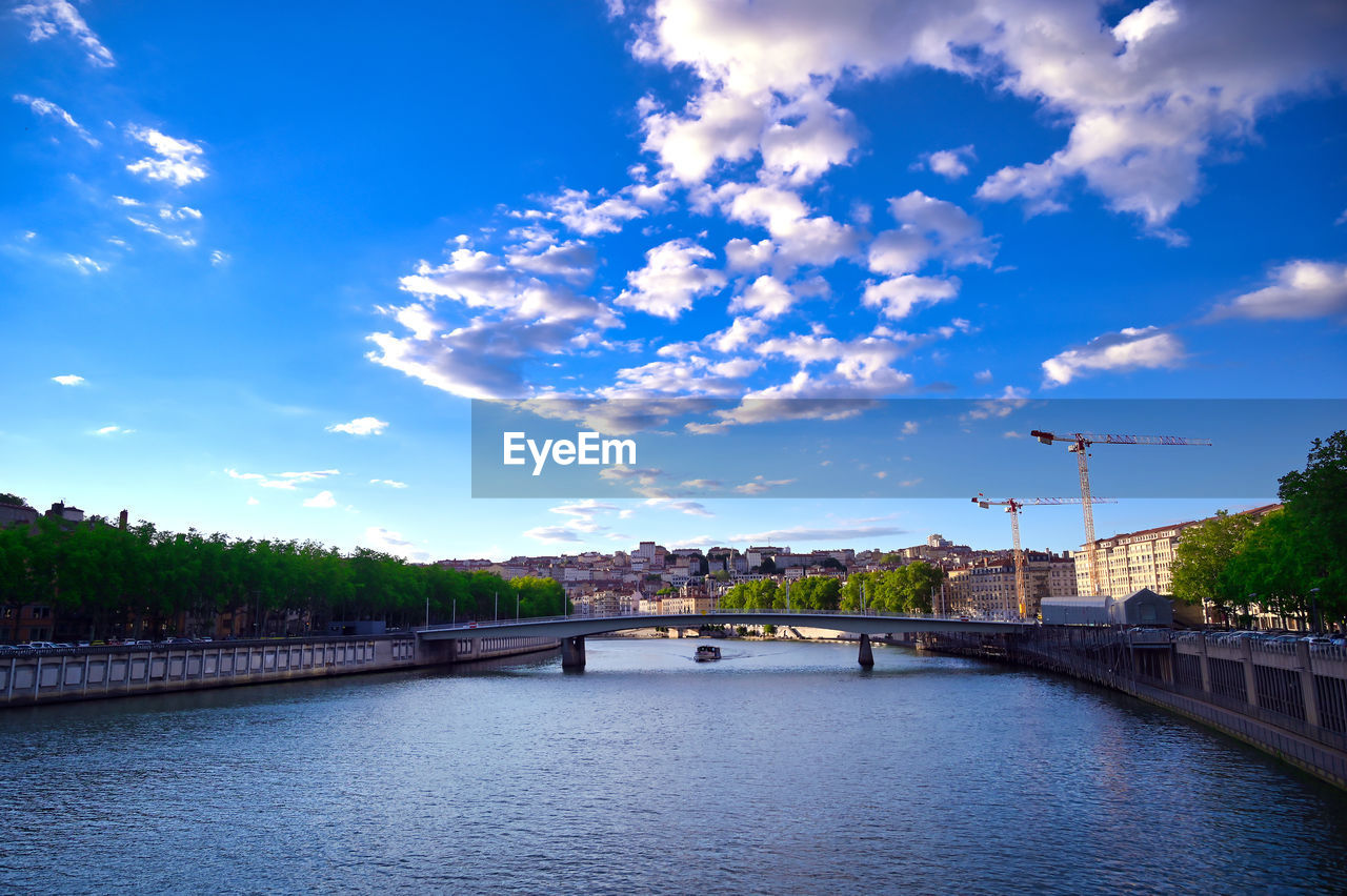 ARCH BRIDGE OVER RIVER AGAINST SKY IN CITY