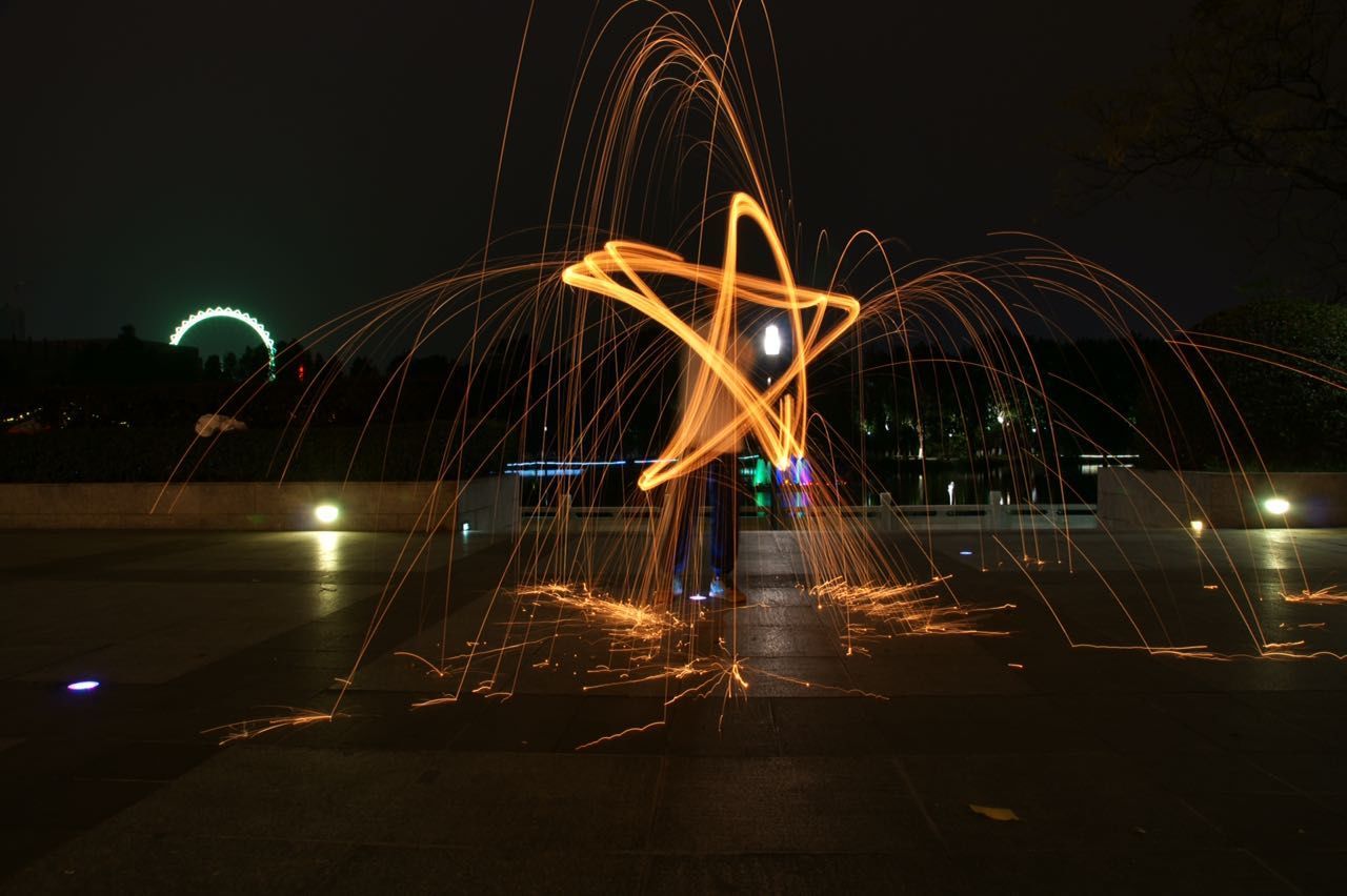 LIGHT TRAILS AGAINST SKY AT NIGHT