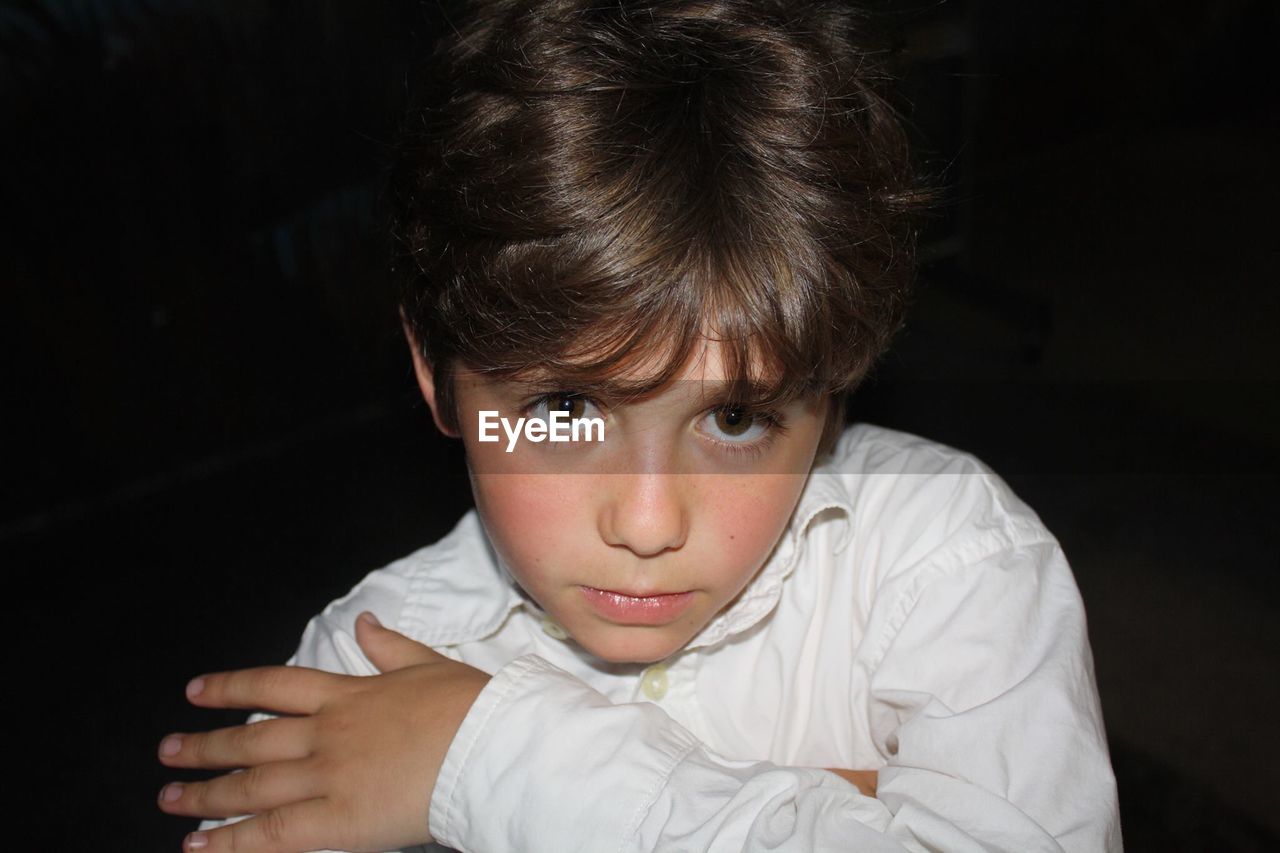 Close-up portrait of boy against black background