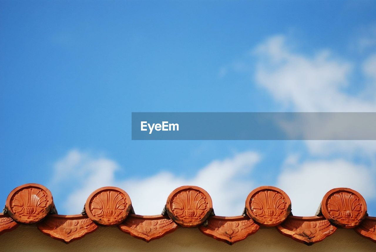 Low angle view of okinawa roof against blue sky