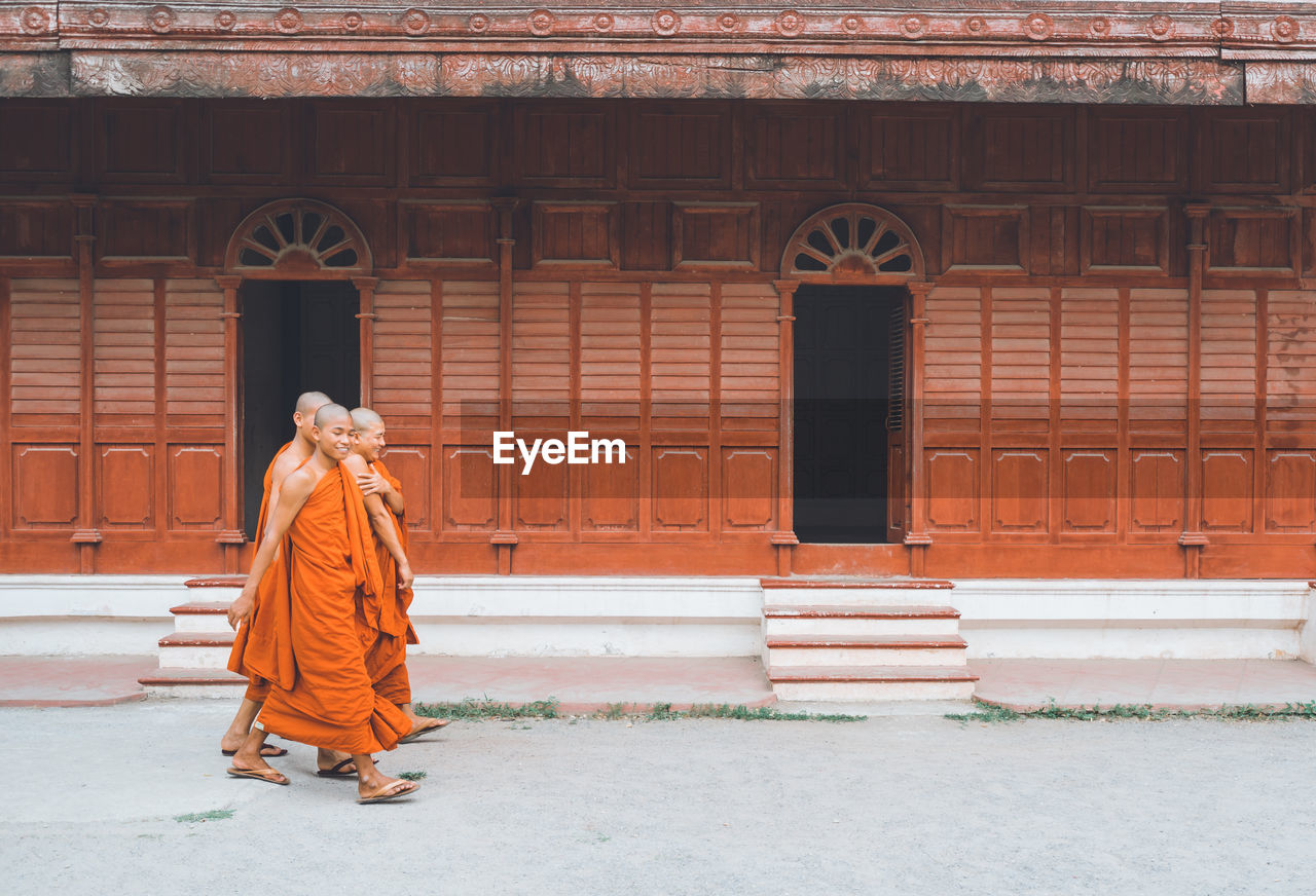 REAR VIEW OF WOMAN WALKING BY DOOR OF BUILDING