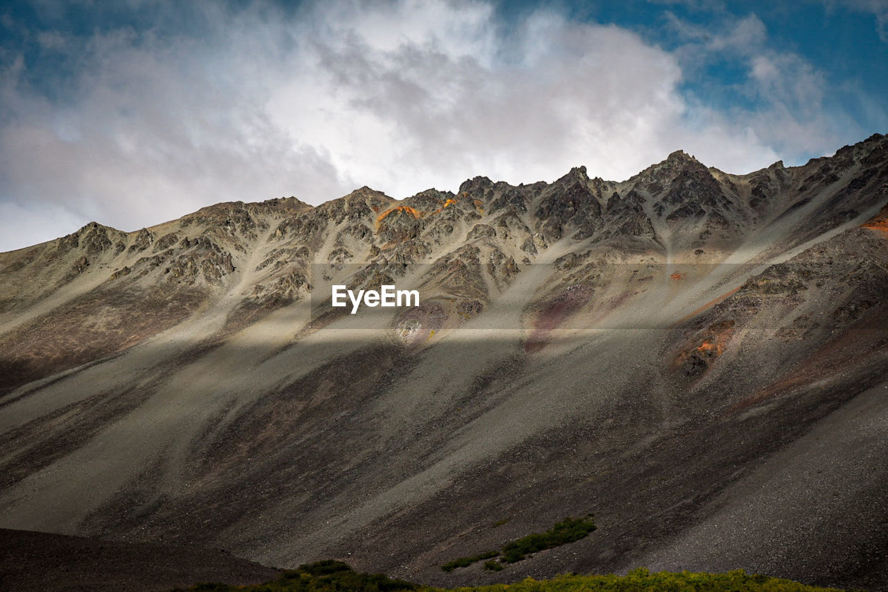 Beautiful rocky mountains with rays of sunshine shining across. clouds and blue skys. 