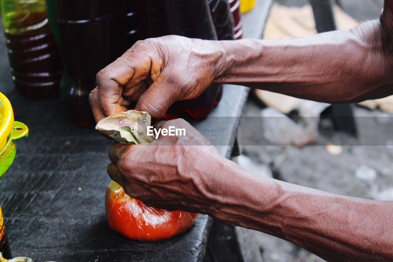 CLOSE-UP OF HAND HOLDING ICE CREAM