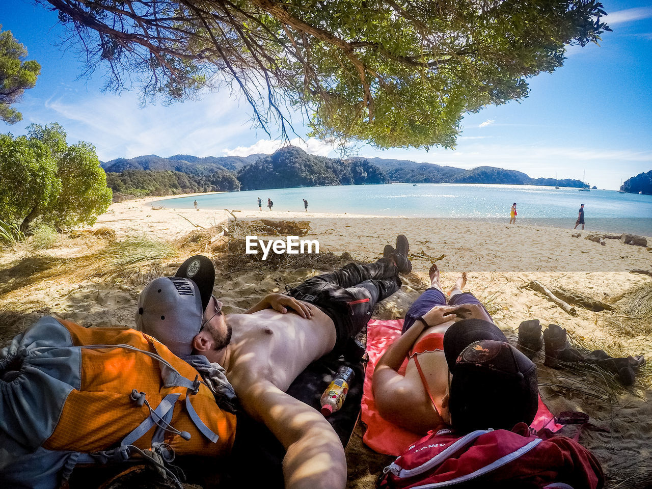 GROUP OF PEOPLE RELAXING ON BEACH