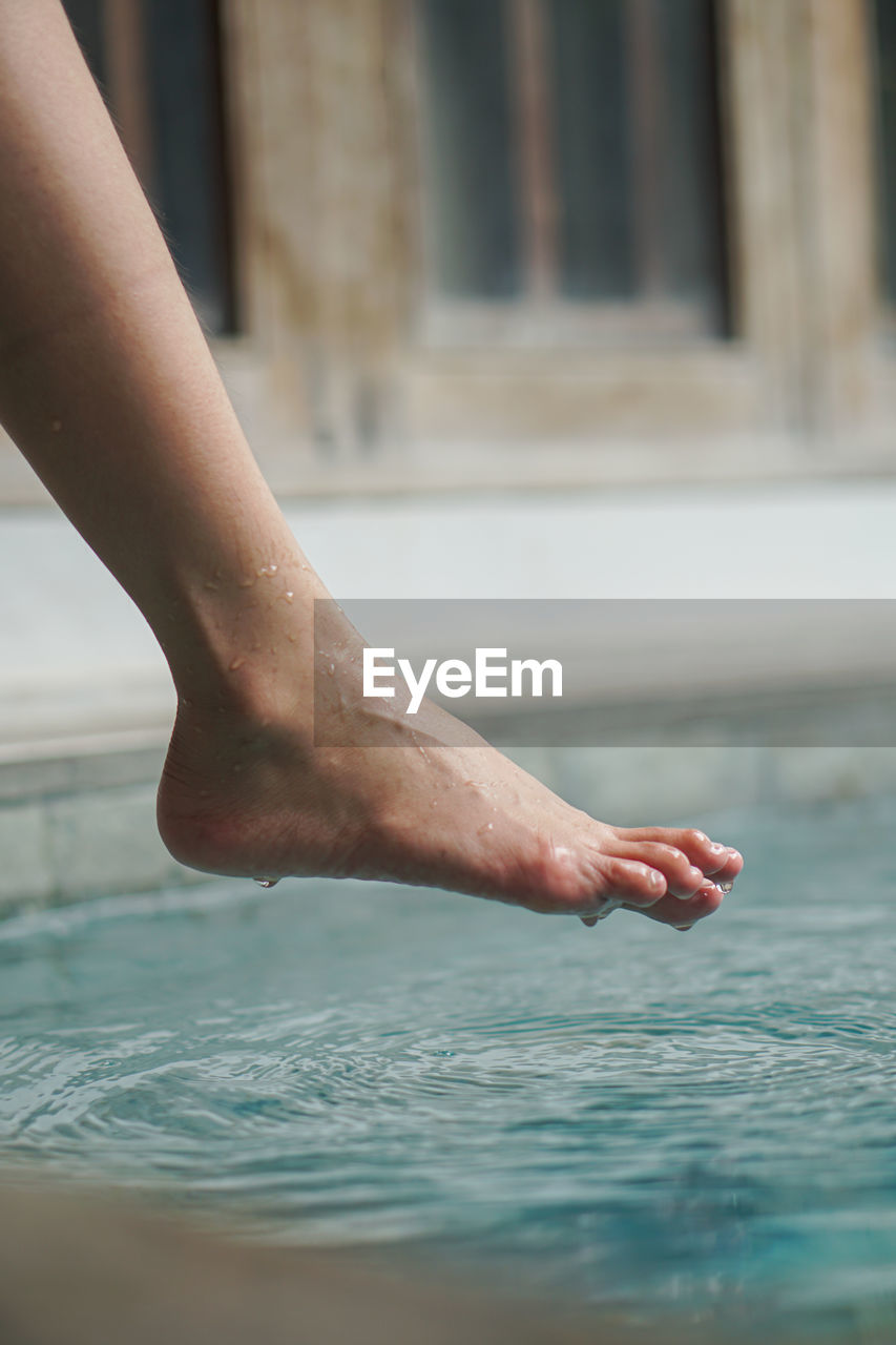 water, swimming, one person, adult, human leg, barefoot, human limb, limb, low section, nature, human foot, relaxation, women, day, swimming pool, trip, holiday, wet, lifestyles, vacation, hand, outdoors, leisure activity, summer, close-up, architecture, young adult, sea, focus on foreground