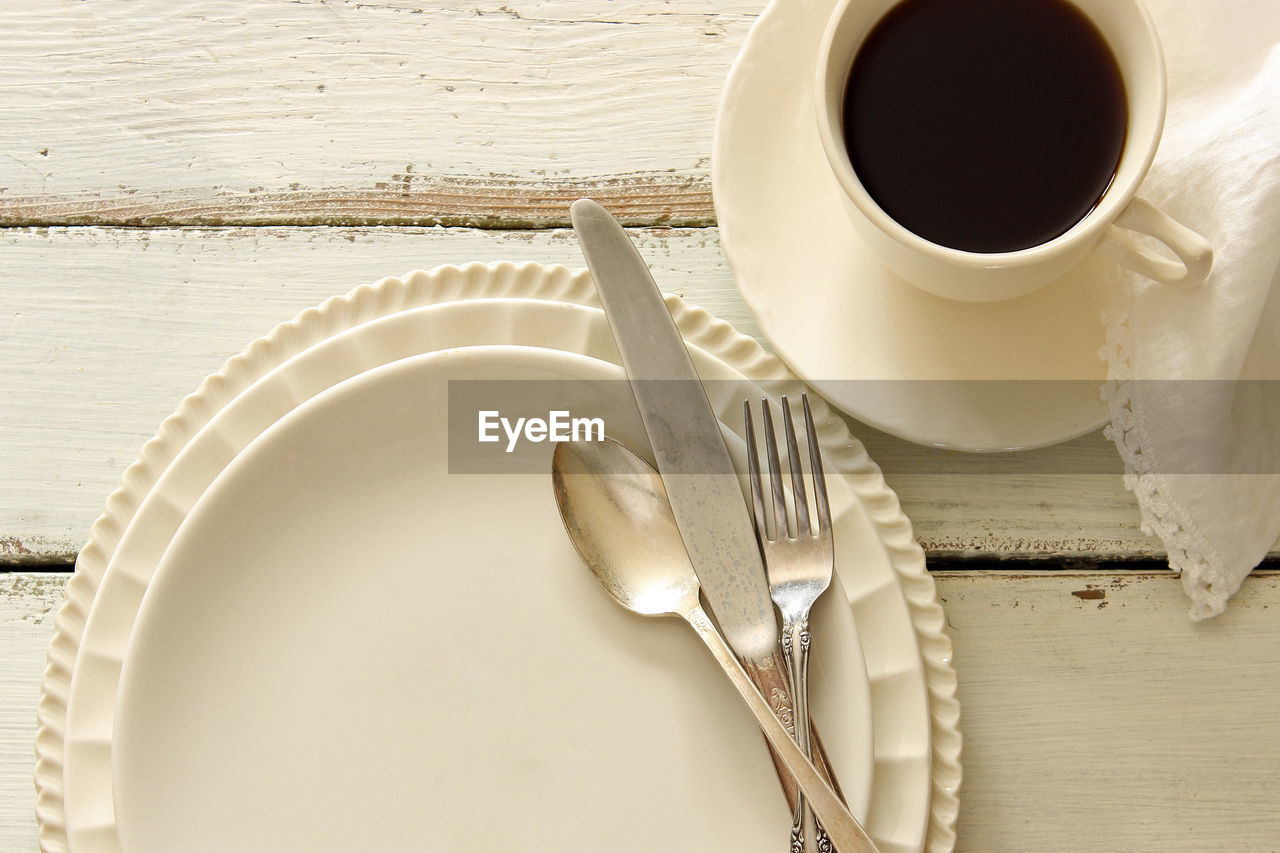 Close-up of plate and coffee cup on table