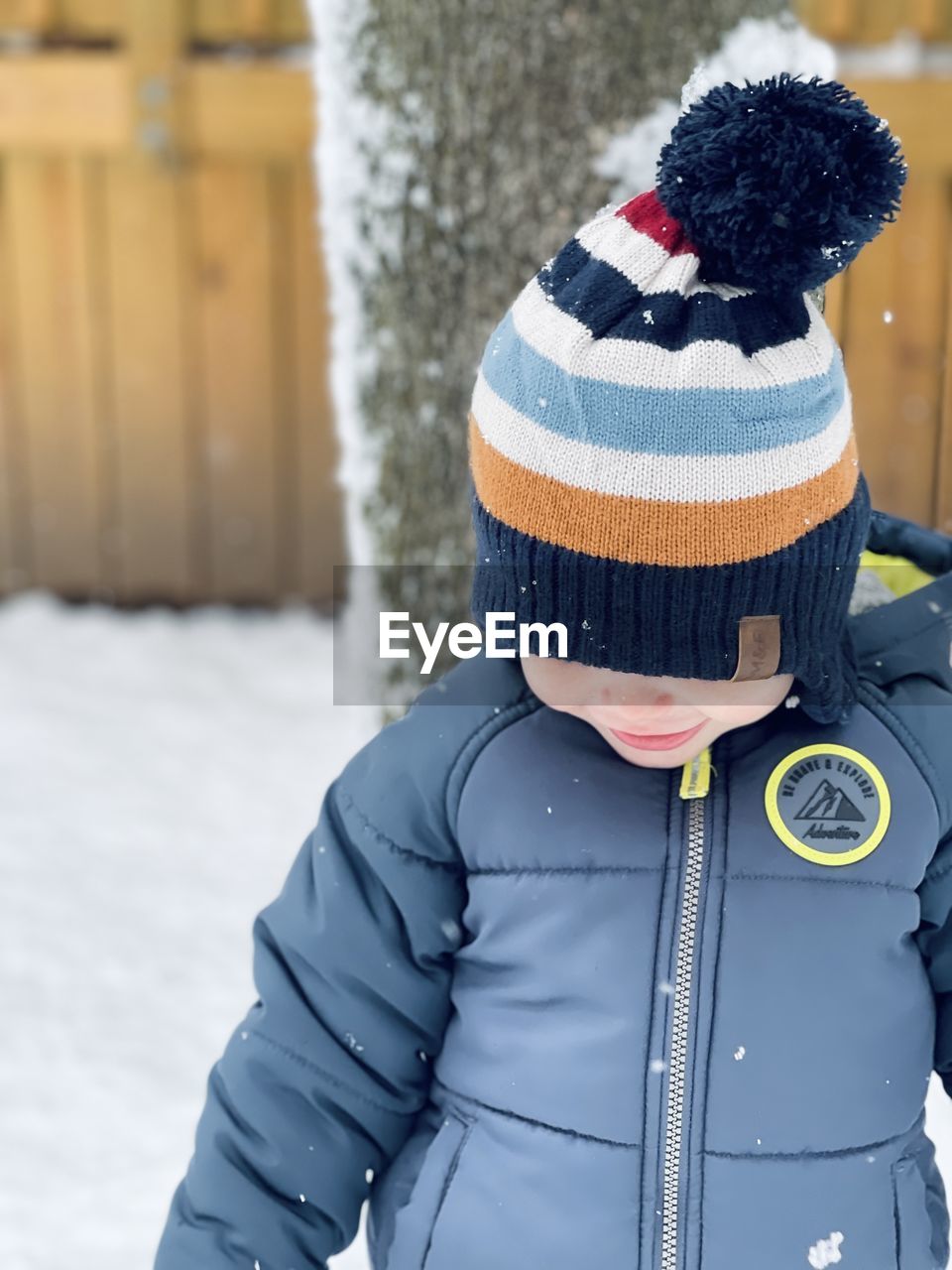 Front view of boy looking down at snow