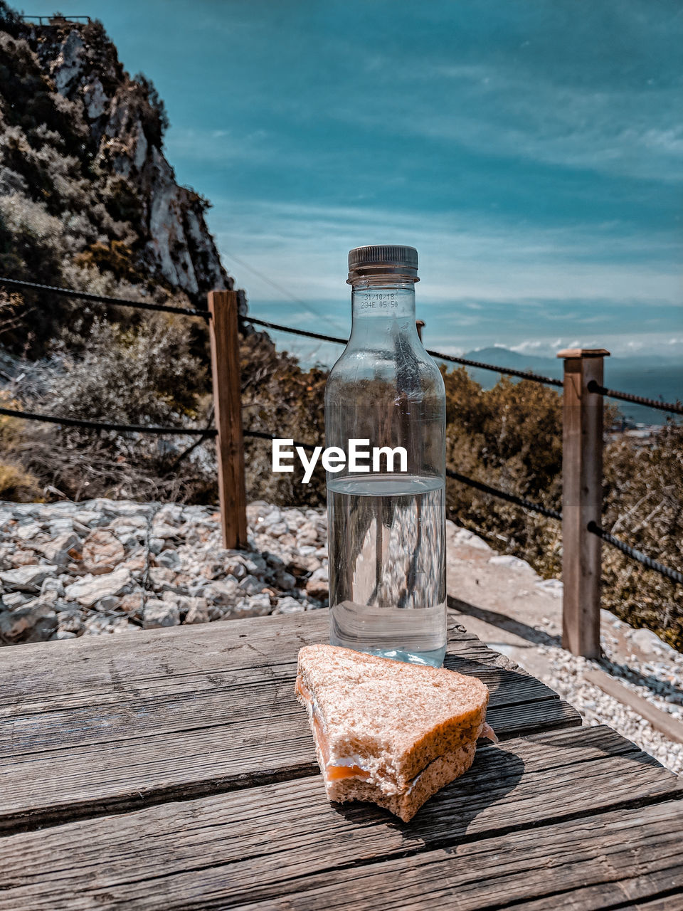 Water bottle and a sandwich for a picnic in overlooking the sea