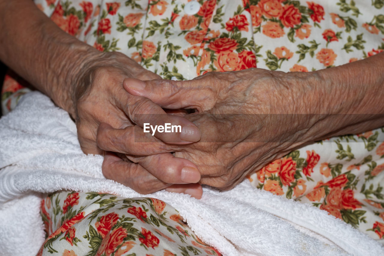 Midsection of senior woman with hands clasped