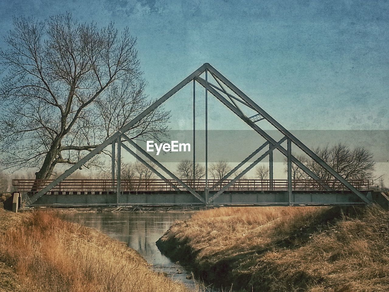 Triangle shape bridge over river against sky