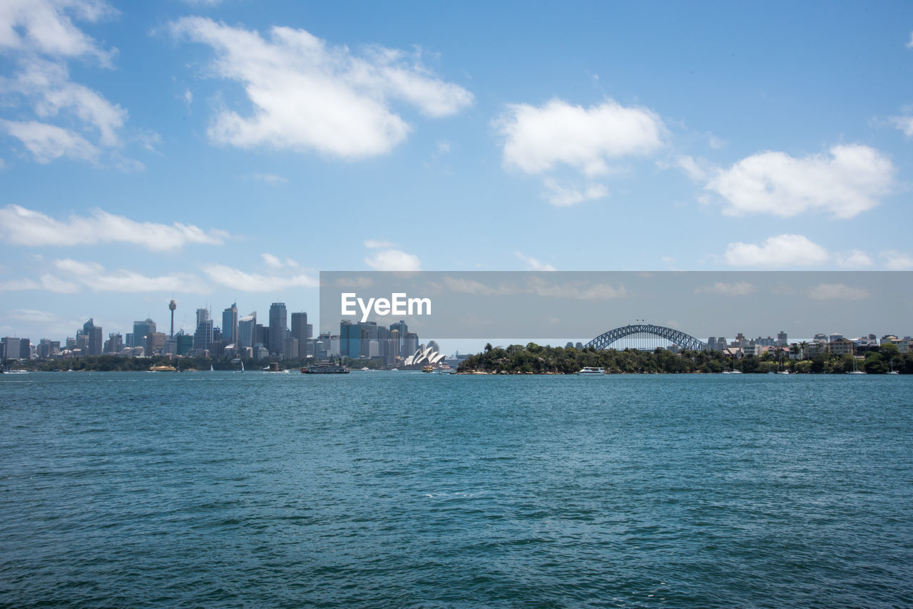 Scenic view of sea by buildings against sky