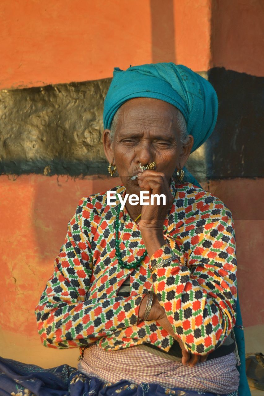 Portrait of a person in traditional clothing smoking