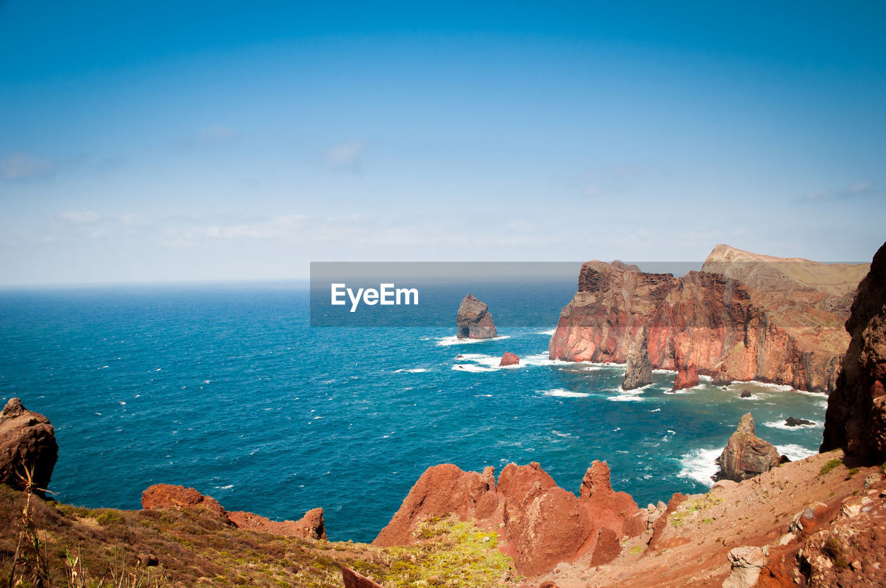 Scenic view of rocks in sea against sky