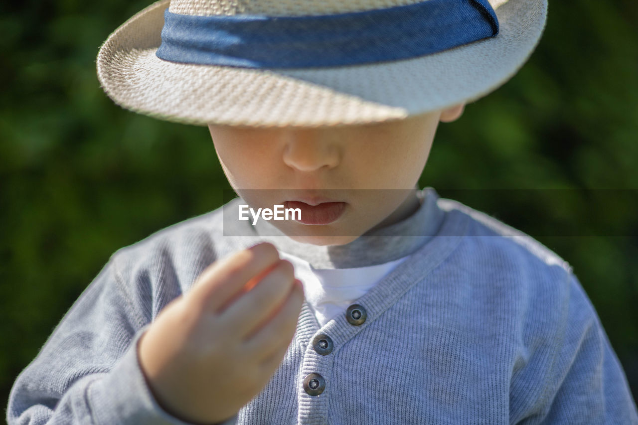 Portrait of boy holding hat