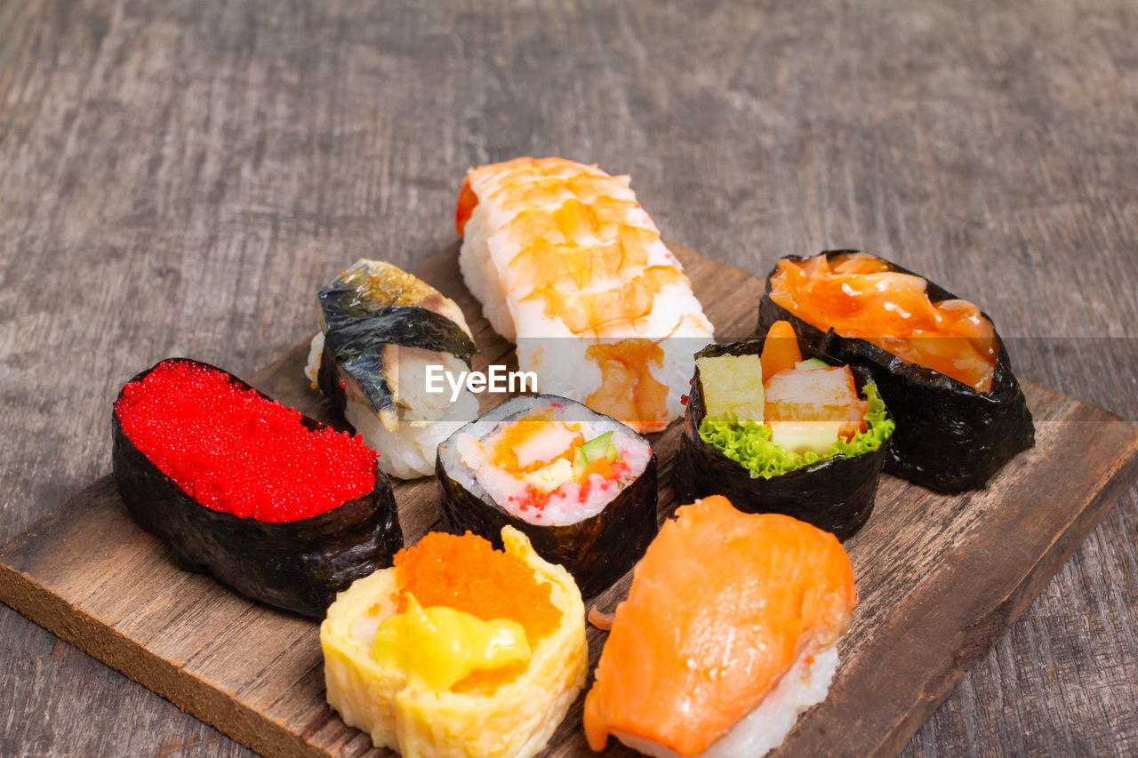 Sushi set sashimi and sushi rolls served on wood slate.copy space for your text.,top view
