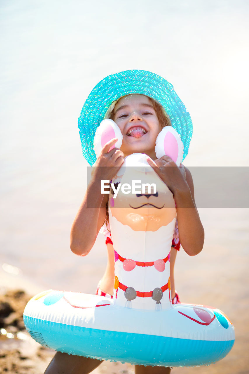 Portrait of cute girl wearing hat on beach