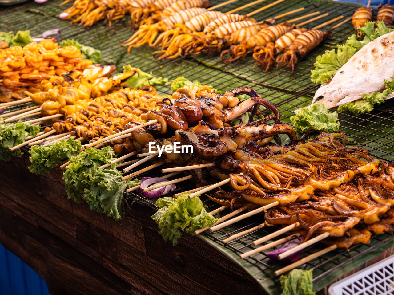 Fresh thai street food. seafood dishes with octopus and squids on skewers in bangkok, thailand.