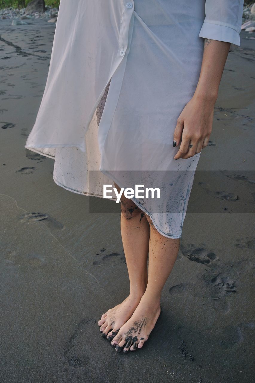 Low section of woman standing on beach