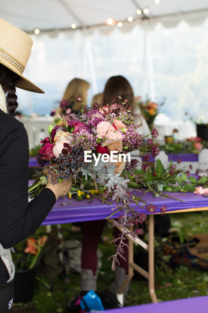 CLOSE-UP OF WOMAN WORKING WITH FLOWER