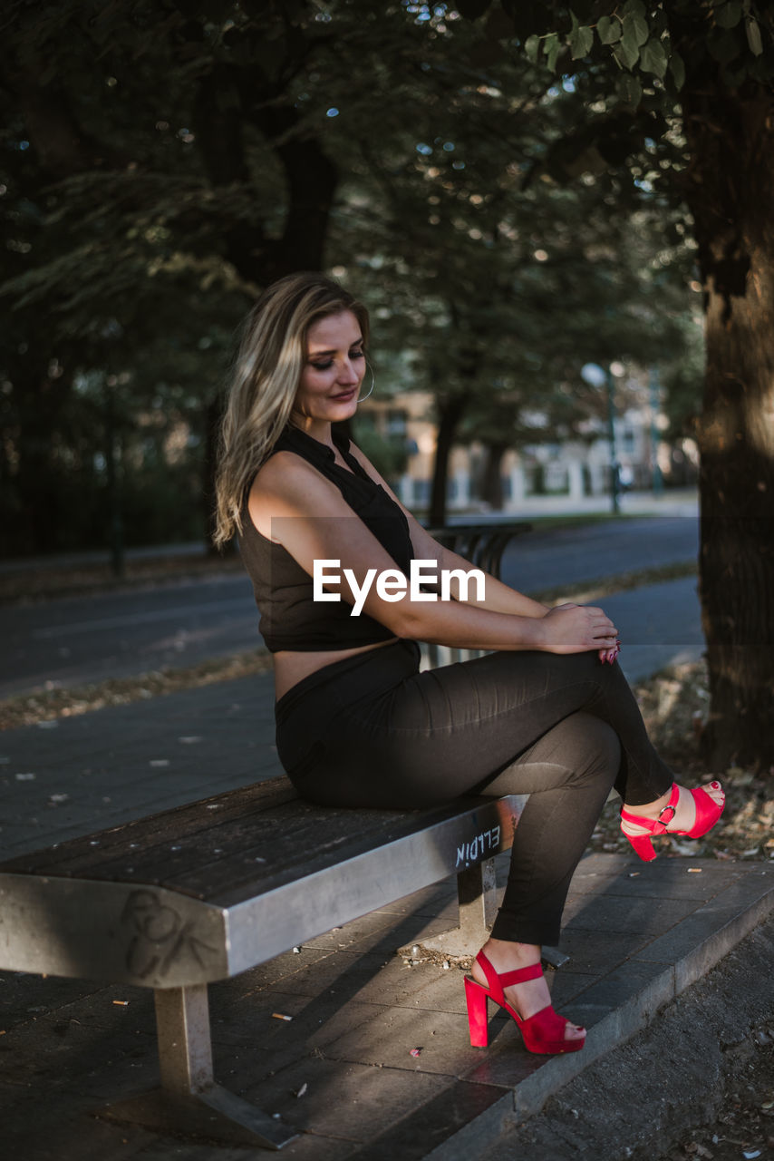 PORTRAIT OF BEAUTIFUL WOMAN SITTING ON SEAT